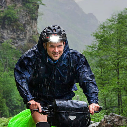 homme a velo pluie avec frontale lampe
