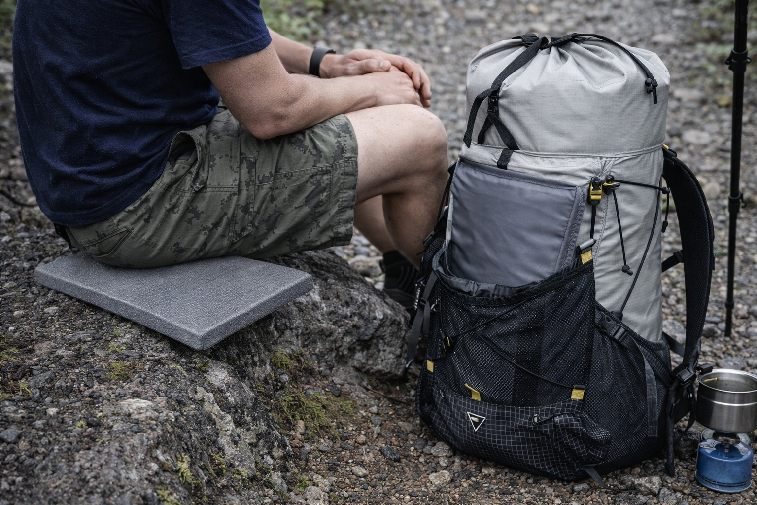 homme assis sur coussin venant du sac a dos randonnee