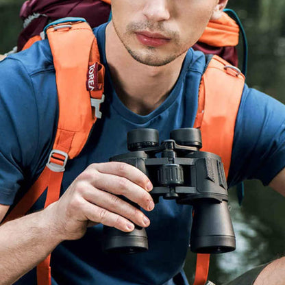 homme avec sac a dos tient jumelles randonnee dans main