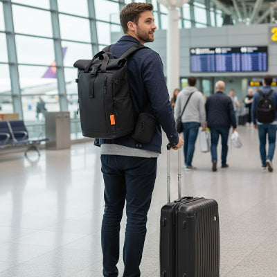 homme avec sac de voyage a dos et valise aeroport