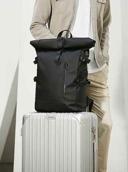 homme avec valise et sac a dos impermeable dessus
