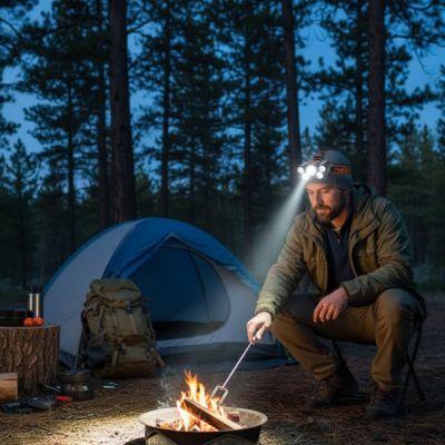 homme camping feu de camp avec lampe frontale rechargeable