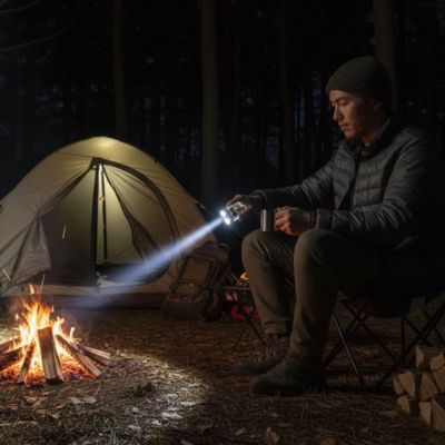 homme avec lampe torche rechargeable feu de camp