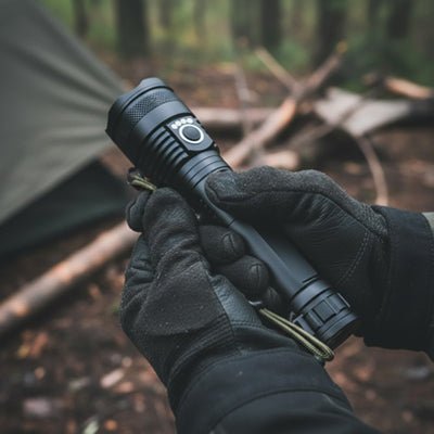 mains tenant lampe de poche campement