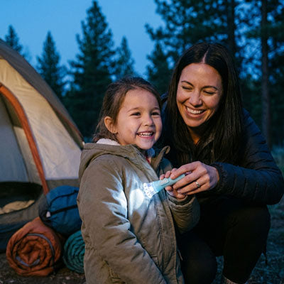 petite fille et maman heureuses avec lampe torche enfant camping
