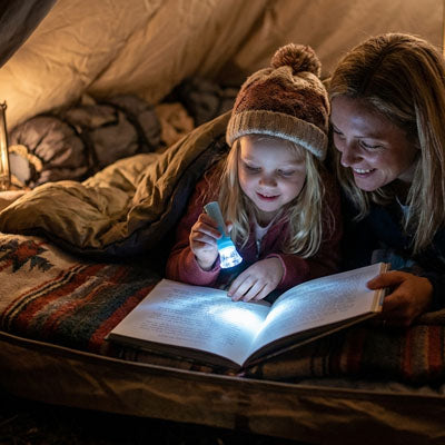 petite fille lit livre dans tente avec lampe torche enfant